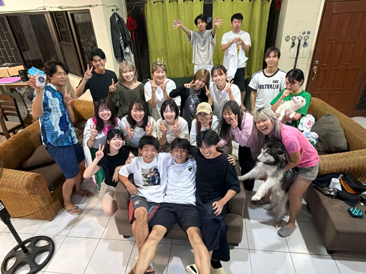 宿泊先の室内でソファを囲み、犬と一緒に撮った参加者たちの集合写真(夜)