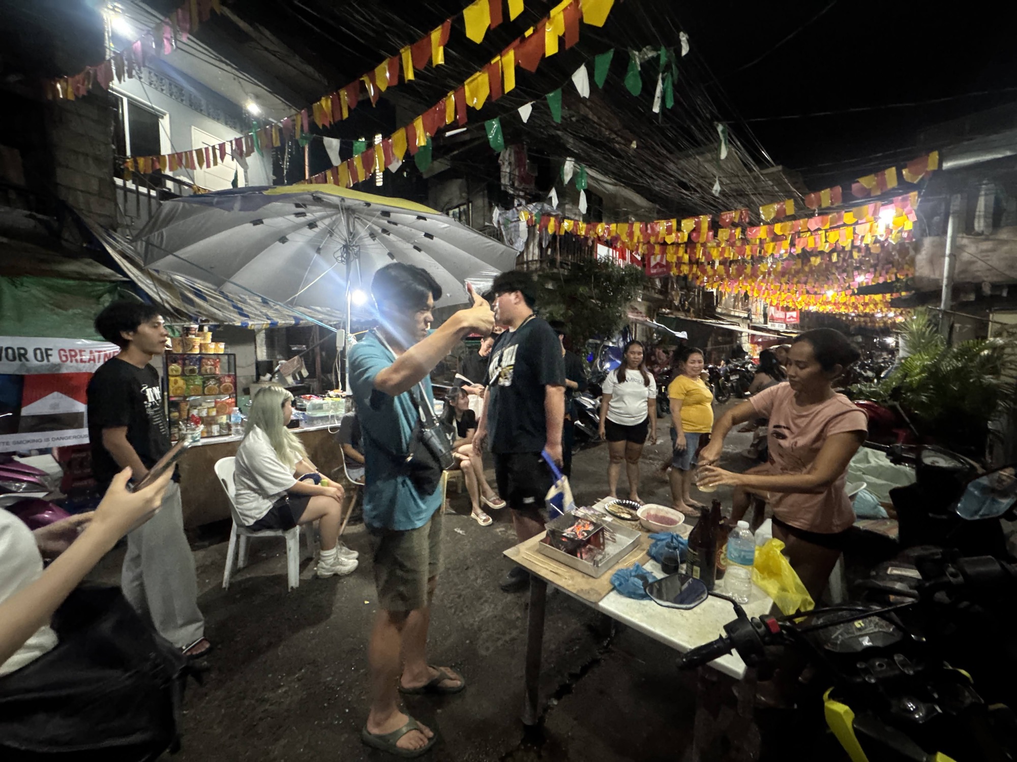 夜の屋台祭りで仲間と食卓を囲む参加者たち