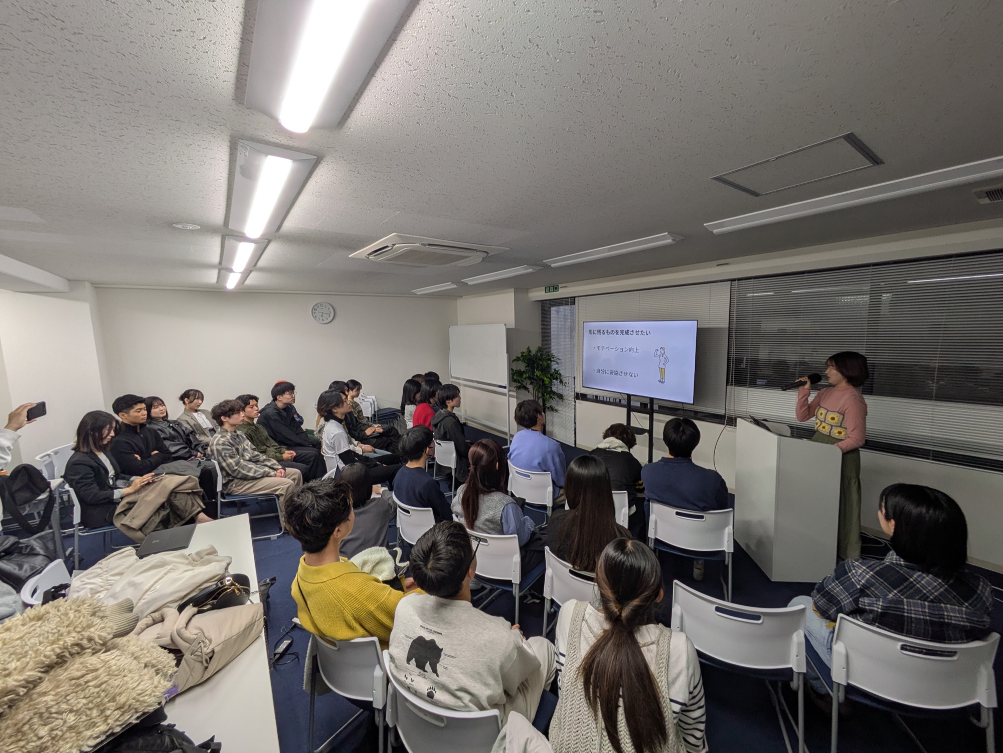 帰国報告会で自分の変化についてスライドを見せながら話す参加者